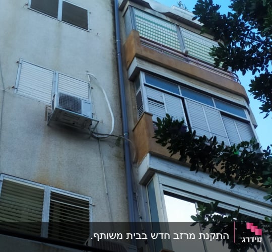 גג בניין עם צינור ניקוז ומזגנים
